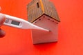 Toy house, thermometer on red color.  Home quarantine concept Royalty Free Stock Photo