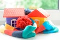 Toy house on the window sill wrapped in a scarf. Warming up the house. Royalty Free Stock Photo