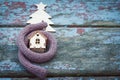 Toy house is wrapped in a warm scarf, it`s snowing. in the backg Royalty Free Stock Photo