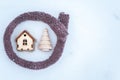 Toy house is wrapped in a warm scarf, it`s snowing. in the backg Royalty Free Stock Photo