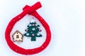 Toy house is wrapped in a warm scarf, it`s snowing. in the backg Royalty Free Stock Photo