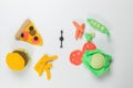 Children's toy knitted food. Pizza, hamburger and French fries on one side and vegetables on the other. Top view on a