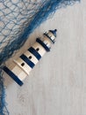 Toy lighthouses nautical blue decorative mesh on a wooden background