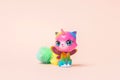 Toy for a little girl. Toy fantasy plastic multi-colored cat with a horn and butterfly wings on a pink background Royalty Free Stock Photo