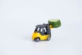 A toy loader or construction crane in bright yellow carries a piece of cucumber and a piece of black freshly baked bread. Close-up Royalty Free Stock Photo