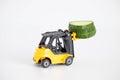 A toy loader or construction crane in bright yellow carries a piece of cucumber and a piece of black freshly baked bread. Close-up Royalty Free Stock Photo