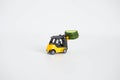 A toy loader or construction crane in bright yellow carries a piece of cucumber and a piece of black freshly baked bread. Close-up