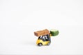 A toy loader or construction crane in bright yellow carries a piece of cucumber and a piece of black freshly baked bread. Close-up Royalty Free Stock Photo