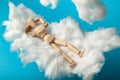 Toy man sleep on fluffy cloud. Freedom and relaxation Royalty Free Stock Photo