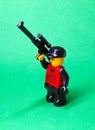 Toy man with a sniper rifle on a green background.