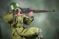 Toy man soldier action figure miniature realistic silk green background Royalty Free Stock Photo