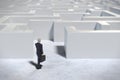 Toy miniature businessman figurine entering a white maze structure Royalty Free Stock Photo