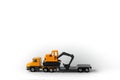 Toy model construction vehicle,cargo yellow low-frame trawl with excavator on trailer, white background,copy space