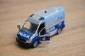 Toy model Polish Police van on a wooden surface.