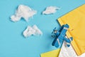 Toy model of a vintage plane made of metal and several parcels on a blue background, cotton wool clouds, air mail concept top view Royalty Free Stock Photo