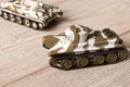 Toy models of Soviet tanks on a wooden table