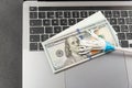 Toy mop and cash dollars on laptop keyboard. Concept of money laundering via the Internet. Online cleaning services Royalty Free Stock Photo