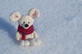 Toy mouse a symbol of the Chinese New Year. In a red knitted scarf. Against the background of white snow. Space for text Royalty Free Stock Photo