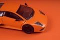 Toy orange car, on orange background. Sports car, close-up shot Royalty Free Stock Photo