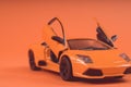 Toy orange car, on orange background. Sports car, close-up shot Royalty Free Stock Photo