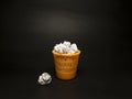 Toy orange dustbin with paper on a black background Royalty Free Stock Photo