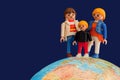 Toy parents and child standing on globe Royalty Free Stock Photo