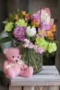 Toy pink Teddy bear sitting on a wooden box Royalty Free Stock Photo