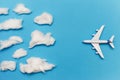 Toy plane on blue background flies to overcast. Flat lay of bad weather and transportation and travel concept