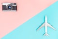 Toy plane and camera on pink and blue background Royalty Free Stock Photo