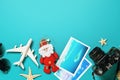 Toy plane, camera, Santa Claus and photos on a blue background. Christmas travel concept with copy space