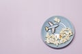 A toy plane flies on a blue plate above popcorn clouds