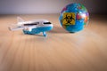 Toy plane next to a globe with the biohazard symbol