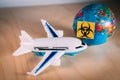 Toy plane next to a globe with the biohazard symbol