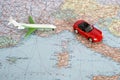 Toy plane and red car on the geographical map of Europe. Travel route planning concept