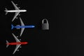Toy planes, repeating the colors of the Russian flag, next to a padlock on a black background. The concept of a no-fly zone,