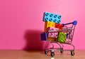 Toy plastic bricks in shopping cart for kids. Plastic construction blocks for children play. Colorful building block in basket Royalty Free Stock Photo