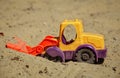 Toy Plastic Bulldozer in the sand. A small digger Royalty Free Stock Photo