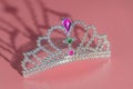 On pink background of toy plastic tiara