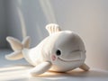 A toy plush whale near a white wall with space for text or design.