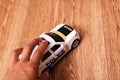 Toy police car in hand on a wooden floor Royalty Free Stock Photo