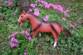 Toy pony among the flowers in the meadow