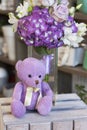 Toy purple Teddy bear sitting on a wooden box Royalty Free Stock Photo