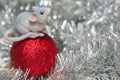 Toy rat on a red Christmas ball close-up on a shiny silver background with bokeh. The year of the rat is 2020 according to the Royalty Free Stock Photo