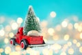 Toy red car with a Christmas tree on the roof on a bokeh festive blue background. Christmas Holiday concept Royalty Free Stock Photo