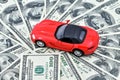 Toy red car and a pot of money dollar bills. Good time to buy a car on credit, save up for a vehicle. Royalty Free Stock Photo