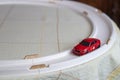 Toy red sport car on a breadboard. racing car on race ring track on the table at home. children`s games at home. Racing car on th Royalty Free Stock Photo