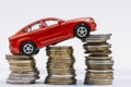toy red car stack increasing coins against white background Royalty Free Stock Photo