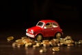 Toy red car top of a stack of coins on a table with dark background Royalty Free Stock Photo