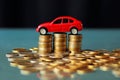 Toy red car top of a stack of coins on a table with dark background Royalty Free Stock Photo