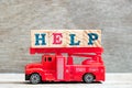 Toy red fire ladder truck hold letter block in word help Royalty Free Stock Photo